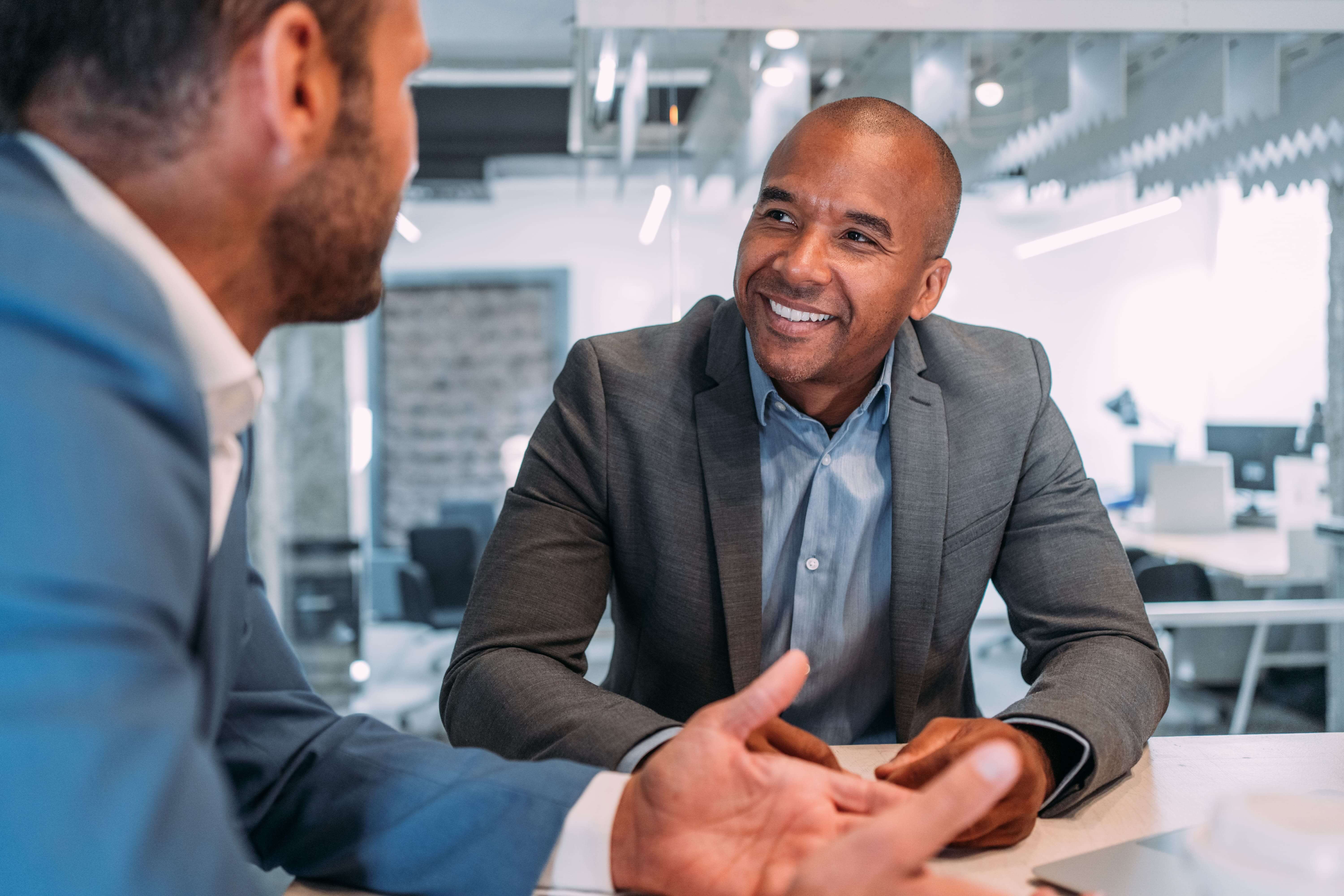 Two men talking in boardroom