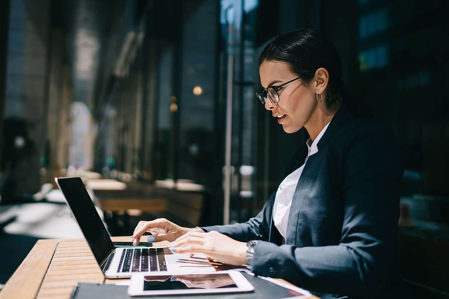 dark-haired businesswoman sitting at computer