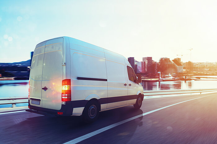 Work van on the highway with city background.