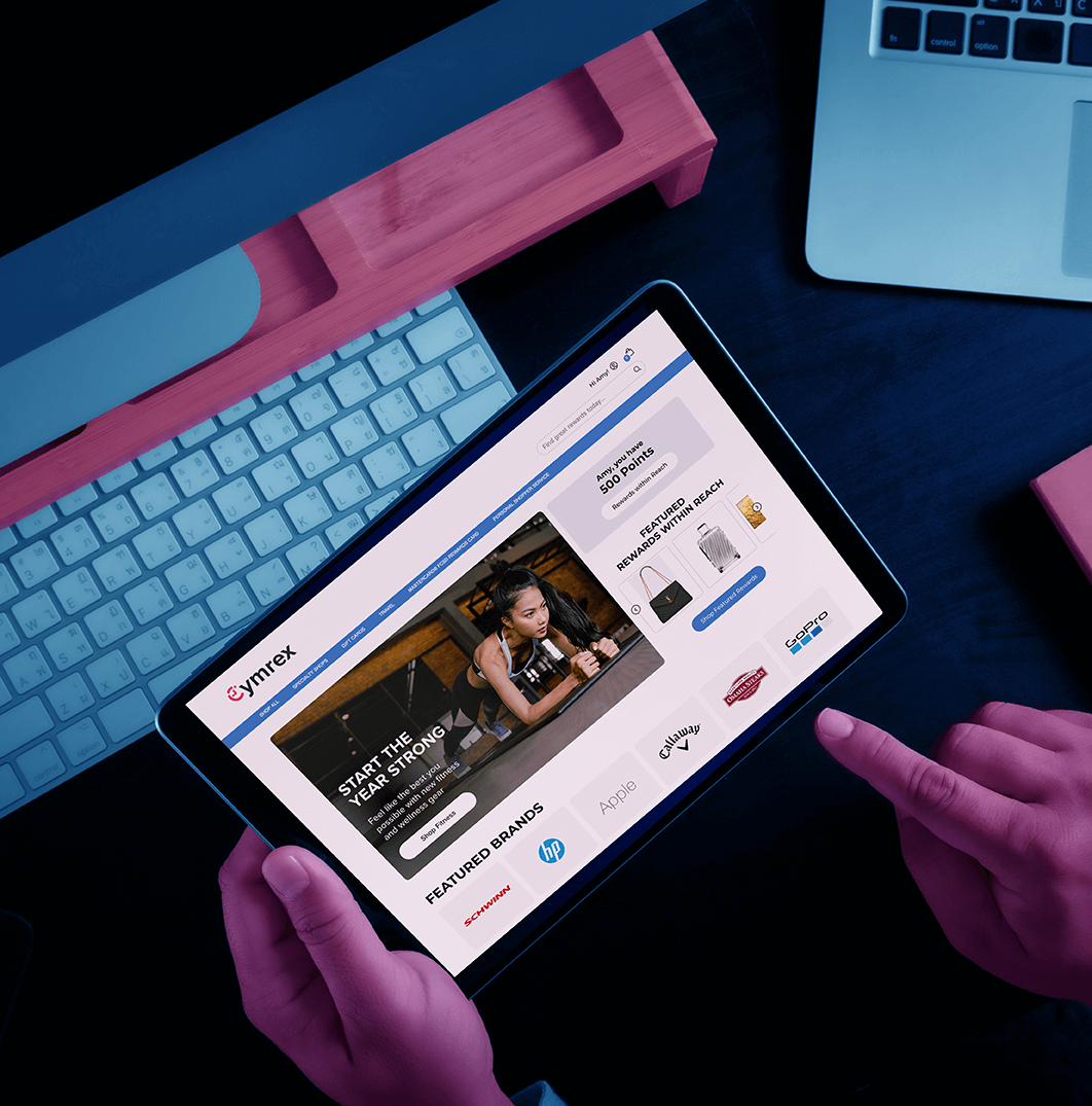 person's hand working on tablet in front of a desktop keyboard