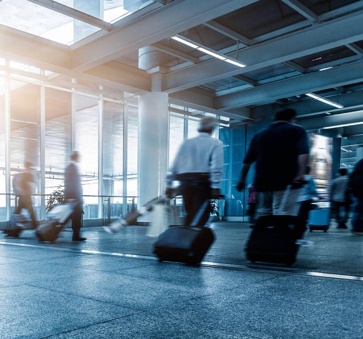 passengers walking through airport dragging suitcases