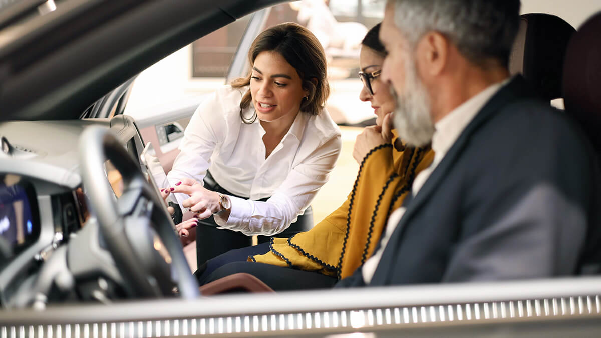 Salesperson demonstrating vehicle features on a tablet