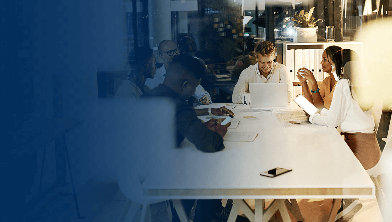 team of coworkers meeting at a table in a modern office