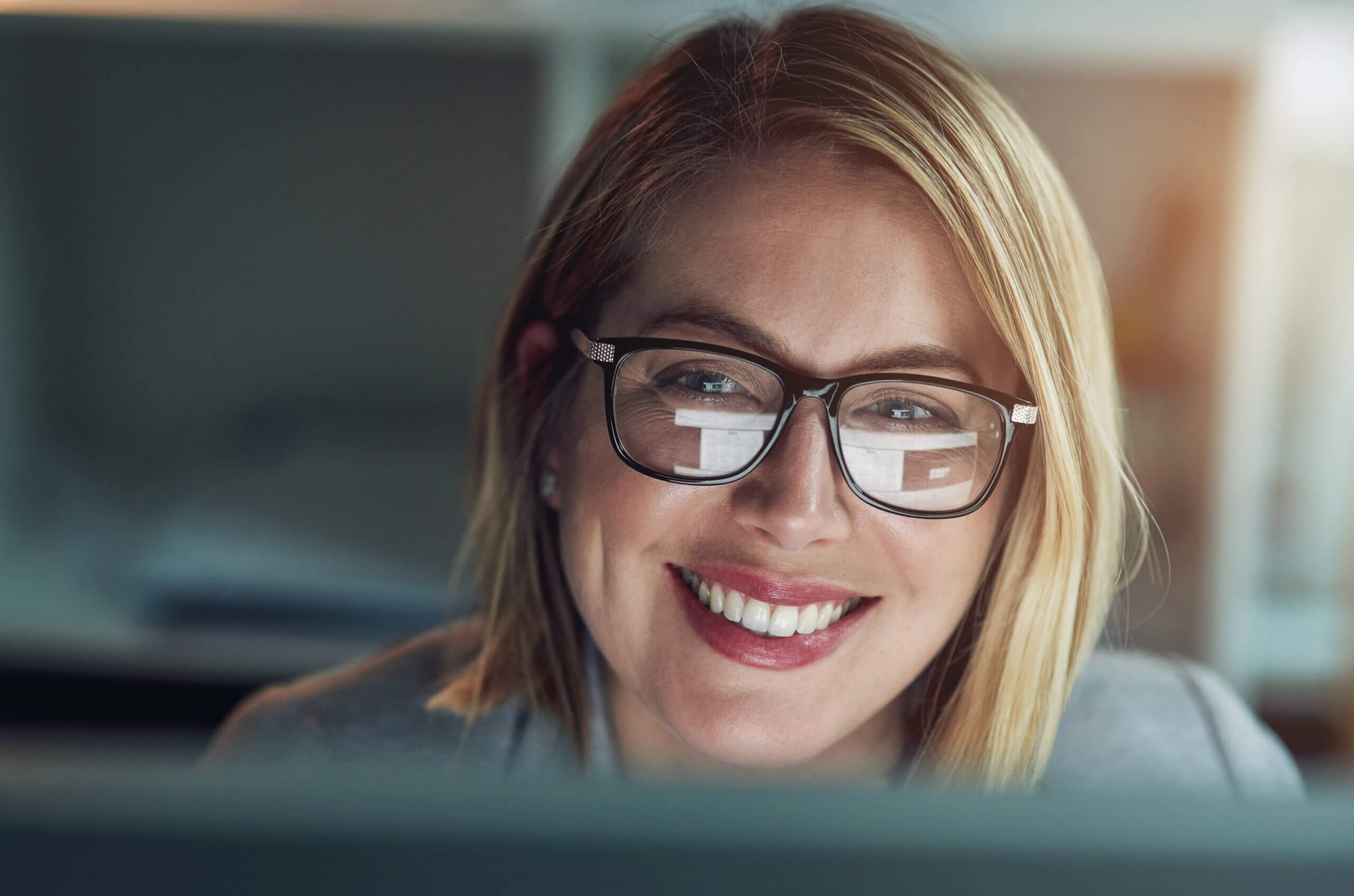 Woman looking at a computer screen and smiling