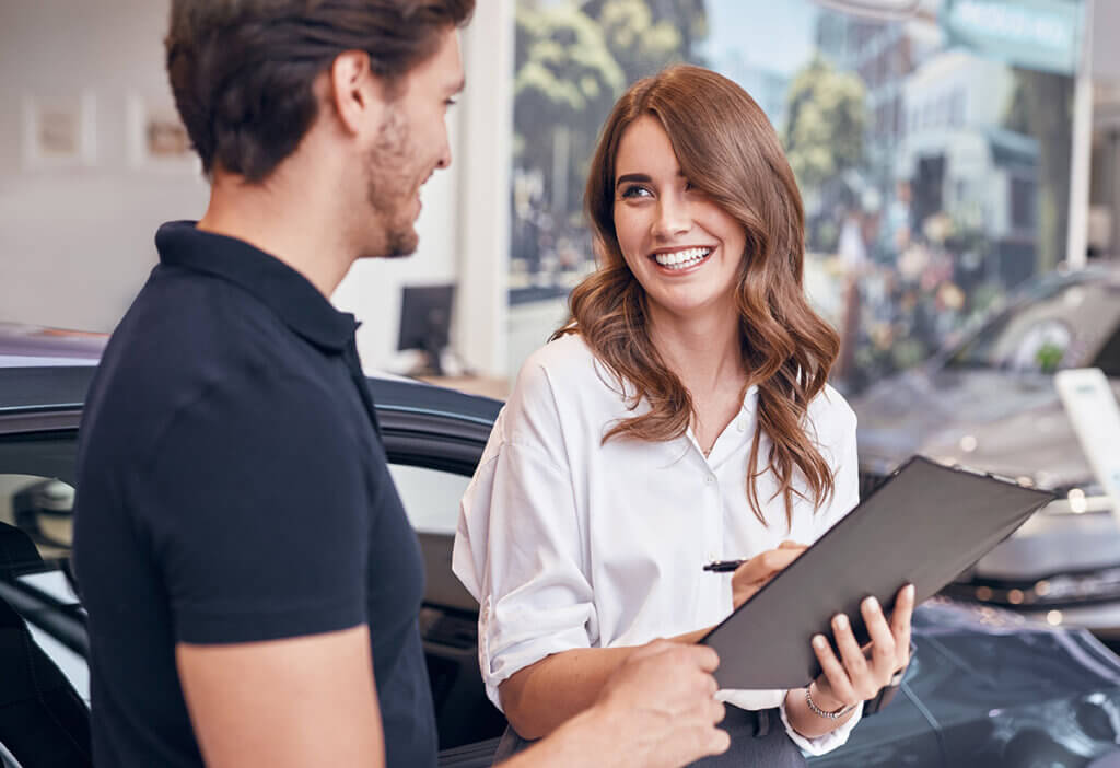 Smiling salesperson consulting with a customer in a dealership