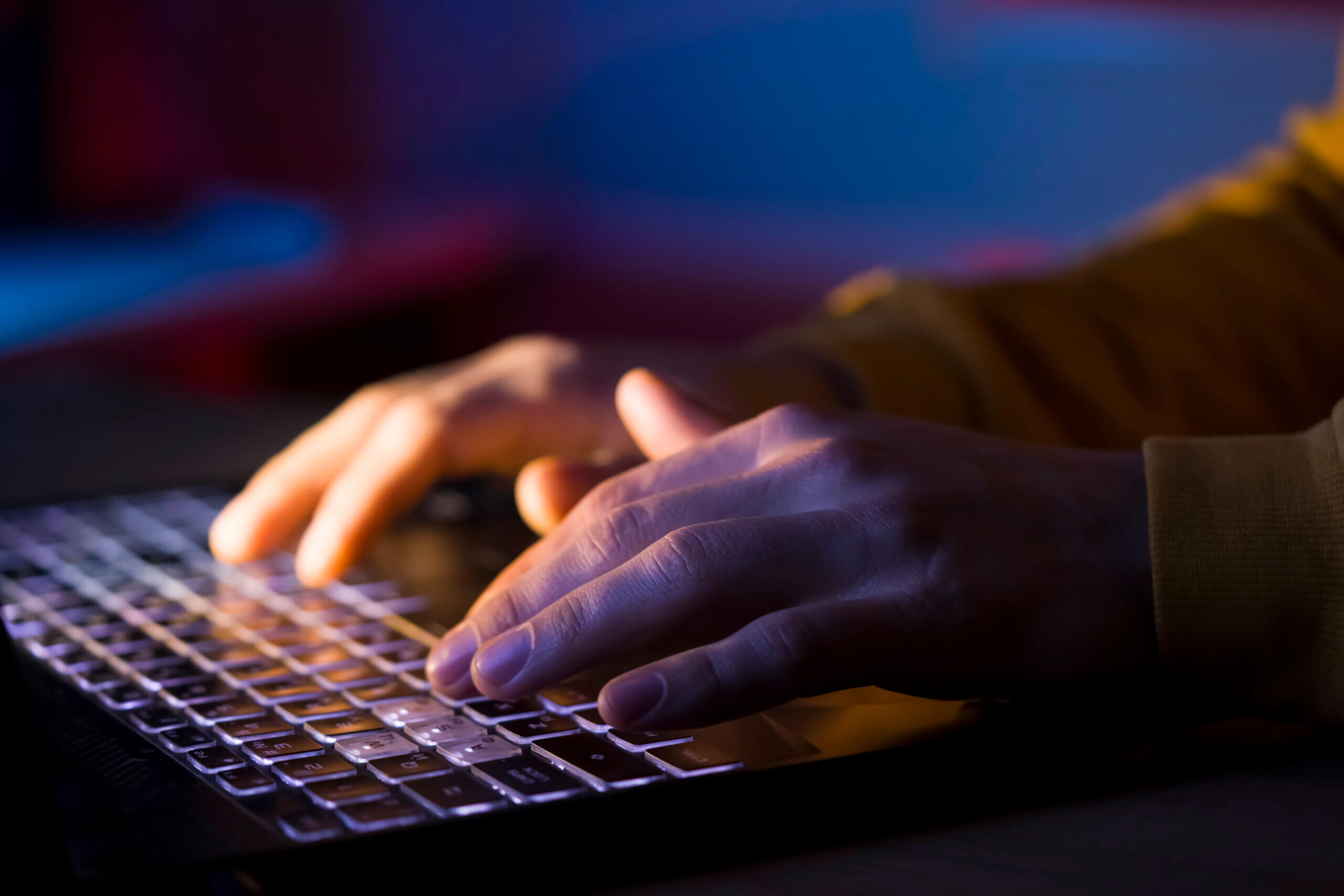 Hands types on a laptop keyboard.