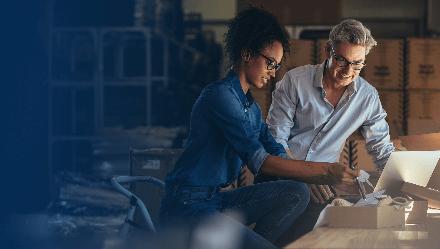 man and woman looking at a box of items to be shipped