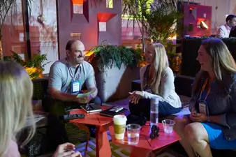 A group of attendees sitting at a table talking.