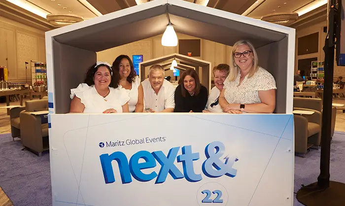 Attendees standing in a box for a photo at the next& event.