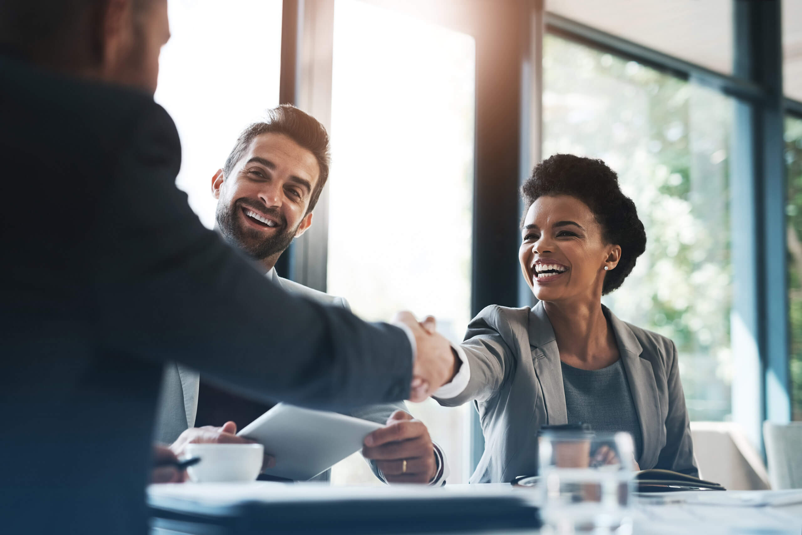 Happy business people, handshake and meeting in teamwork for partnership or collaboration in boardroom. Woman person shaking hands in team recruiting, introduction or b2b agreement at the workplace.